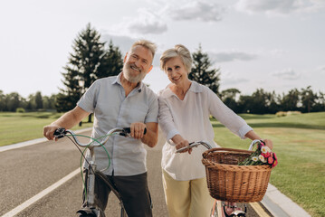 Loving aged couple with vintage bicycles at summer park - 767884866