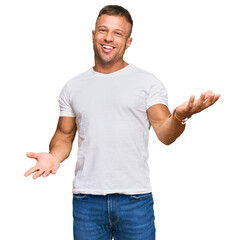 Handsome muscle man wearing casual white tshirt smiling cheerful with open arms as friendly...