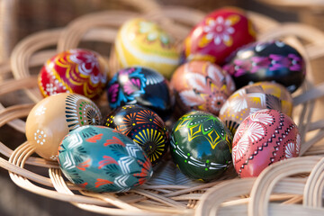 Traditional Lithuanian wooden colorful Easter eggs in a wicker basket, symbol of fertility and life...