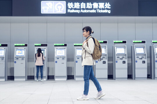 Backpacker traveler walks past ticket vending machine at train station