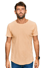 Obraz premium Handsome young man with beard wearing casual tshirt looking at the camera blowing a kiss on air being lovely and sexy. love expression.