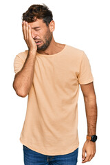 Handsome young man with beard wearing casual tshirt yawning tired covering half face, eye and mouth...