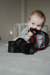 Little boy photographer lying with camera at home - 767895628