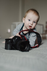 Little boy photographer lying with camera at home - 767896051