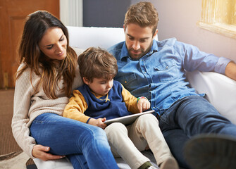 Family, parents and child with tablet for streaming, relax on couch with cartoon or e learning games at home for bonding. Love, care and trust with digital tech, play online or people watch a movie