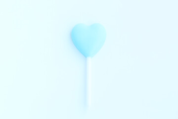 Blue heart shaped lollipop on blue background, Chocolate candy 