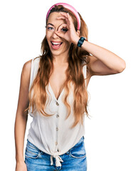 Obraz na płótnie Canvas Young caucasian woman wearing casual style with sleeveless shirt doing ok gesture with hand smiling, eye looking through fingers with happy face.