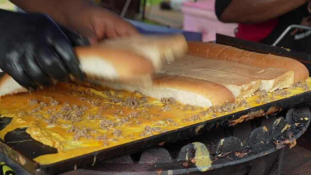 Close-up view of a hawker preparing Malay traditional sandwich, popular in Indonesia, Malaysia and Singapore called Roti John on the pan.