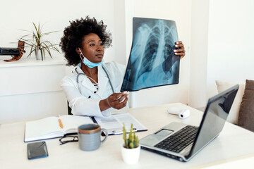 Shot of a young female doctor examining an x-ray in an office.