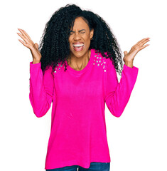 Middle age african american woman wearing casual clothes celebrating mad and crazy for success with...