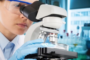 Female scientist in the lab, using a microscope