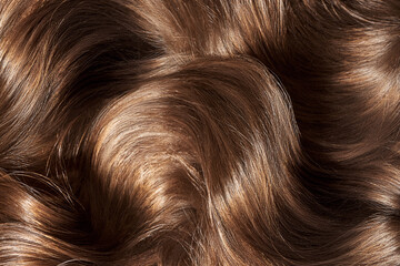 Brown hair background. Women's long brown hair. Beautifully styled wavy shiny curls.