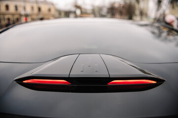 Headlight the car from above above the trunk. Stop signal. Back view. Luxury car outdoors. Exterior...