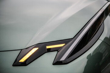 Right front light shining on new modern electric sedan car. Modern concept supercar exterior design...