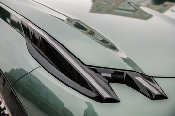Headlight - modern concept supercar exterior design detail. Right turn indicator signal. Front...