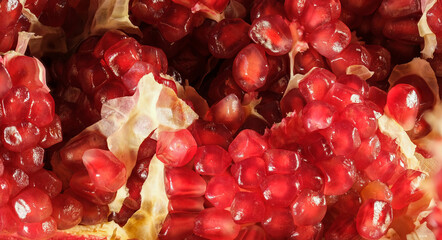 broken pomegranate with red ripe juicy kernels close-up