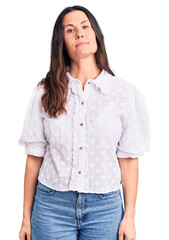 Young beautiful brunette woman wearing casual shirt relaxed with serious expression on face. simple and natural looking at the camera.