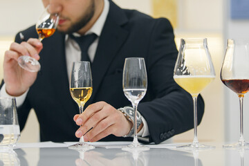 Professional sommelier sniffing various alcoholic drink during blind tasting. Sommelier exam to study different wine and whiskey.