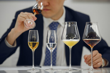 Professional sommelier sniffing unknown alcoholic drink during blind tasting. Sommelier exam to study different wine and whiskey.