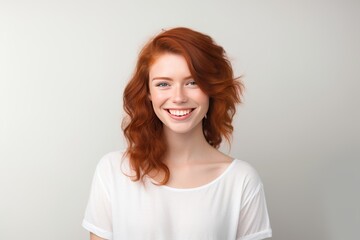 Obraz premium Attractive, happy and smiling young woman with red hair, isolated on a plain background 