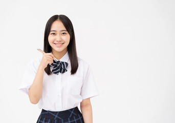 制服を着た日本人女子高校生/ペンを持っている/白背景スタジオ撮影	