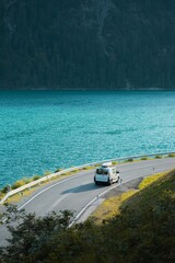 a van on the road by the water driving along the ocean © Wirestock