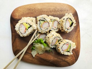 Wooden board with sushi rolls