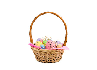 Fototapeta na wymiar Decorative colorful Easter eggs in a wicker basket isolated on white background. Easter decor.