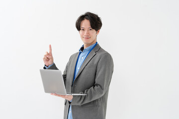 ノートパソコンを持って指差しをする男性