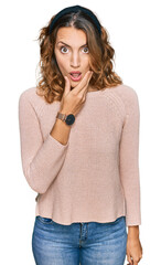 Fototapeta premium Beautiful young caucasian woman wearing casual sweater looking fascinated with disbelief, surprise and amazed expression with hands on chin