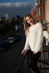 Young attractive blonde woman standing on the balcony	