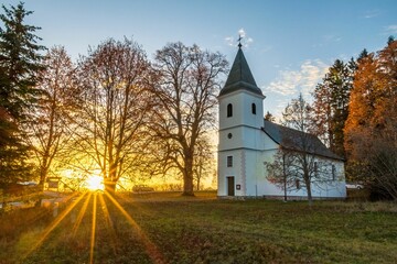 Picturesque church at sunset surrounded by lush trees. Banska Bystrica, Slovakia.