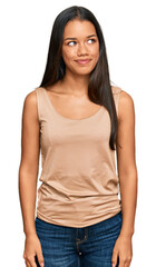 Obraz premium Beautiful hispanic woman wearing casual clothes smiling looking to the side and staring away thinking.