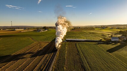 Aerial View at Sunrise of a Steam Passenger Train Approaching Blowing A Lot of Smoke