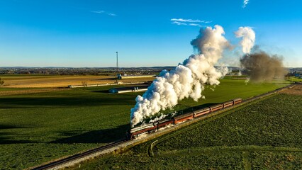 Aerial View at Sunrise of a Steam Passenger Train Approaching Blowing A Lot of Smoke