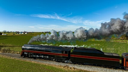 Aerial Side View of an Antique Streamlined Steam Locomotive Running By Blowing Black Smoke,