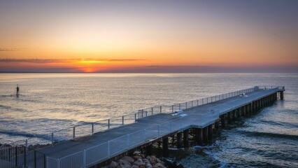 Scenic view of a pier on the sea at golden sunset