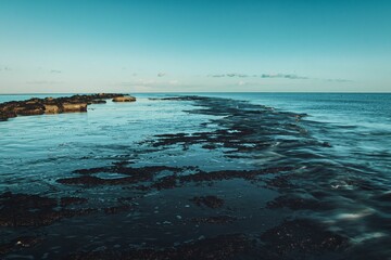 a beach with a long sandy coast line that is next to the ocean