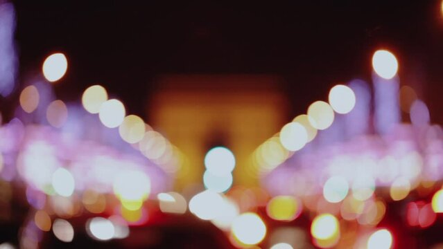 Champs-Elysees city street with defocused traffic lights at night in Paris