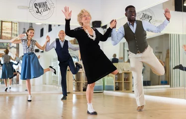 Photo sur Aluminium École de danse Man and elderly woman performing jazz dance in dancing room