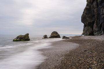 Water waves of the Black Sea crashing on rocks on the stony shore, coast - close up, nobody, no people. Nature, element, landscape