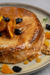 cake with dried apricots, raisins and walnuts on grey background