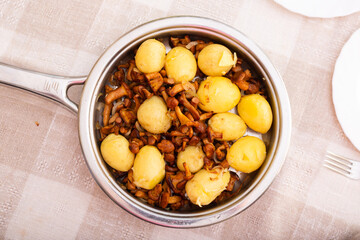 Delicious forest mushrooms chanterelles with young potatoes fried in frying pan. top view