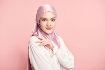 Beautiful young asian muslim woman wearing a pink hijab on pink background, Portrait of Arab Beauty.