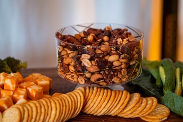 Fourchette table with a bowl filled with a variety of nuts,salty cookies and cheese