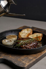 Pan-fried steak with toast and rosemary, drizzled with olive oil