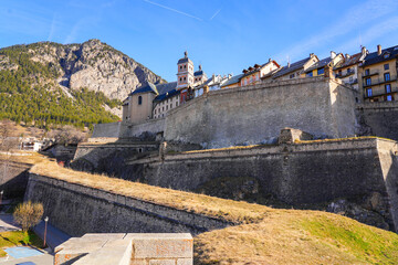 Collegiate Church of Our Lady and Saint Nicholas of Briançon above the walls of the fortified old town of Briançon built by Vauban in the French Alps - obrazy, fototapety, plakaty