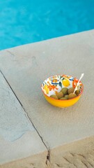 Closeup of a bowl of green olives by a pool in Tuscany
