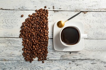 Top view of coffee beans and coffee cup on a wooden table