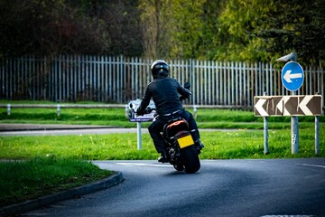 a man riding on the back of a motorcycle down a street